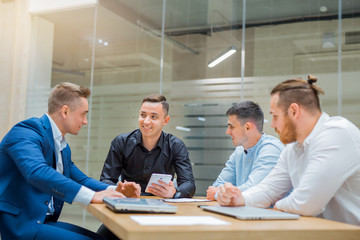 meeting of men entrepreneurs at the table in the office