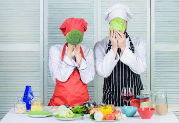 Healthy food concept. Couple cooking healthy vegetarian meal. Vegetarian family. Vegetarian nutrition and vegetable diet. Diet on their mind. Couple cooks hold cabbage and broccoli in front of face