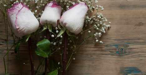 roses bouquet over wooden table.