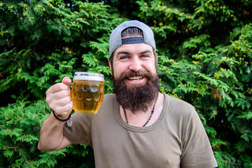 Beer is great summer drink. Bearded man holding beer mug on summer nature. Brutal hipster drinking...