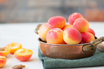 Fresh ripe apricots in a vintage bowl on a sackcloth.