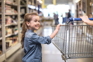 Mother and daughter shopping in supermarket choosing products