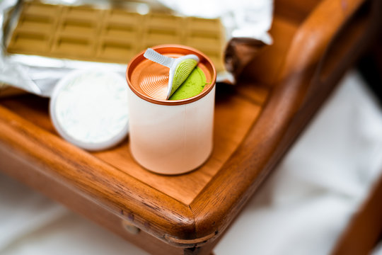 Blurred defocus image with a cylindrical open box with green Chinese tea powder match