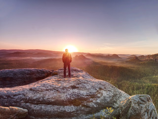 Moment of loneliness. Man with hands in pockets on the rock