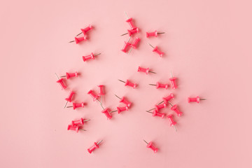 Scattered pink paper pin. Pink background. Flatlay.