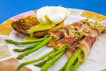 Green boiled Asparagus with Poached Egg, with salt and spices on plate