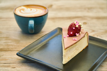 Delicious latte coffee and cheesecake on the wooden table