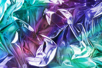 Modern beautiful holographic background of blurred crumpled foil. Trendy 80's style. Wallpaper design.