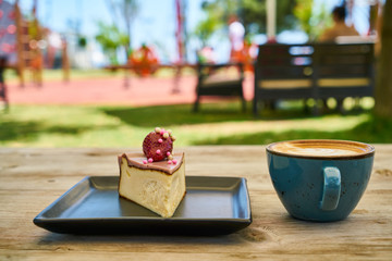 Latte coffee and cheesecake on the wooden table