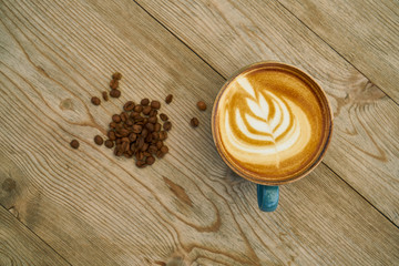Latte coffee and coffee beans on the wooden table