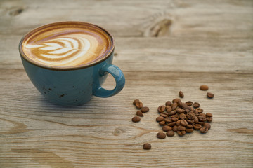 Latte coffee and coffee beans on the wooden table