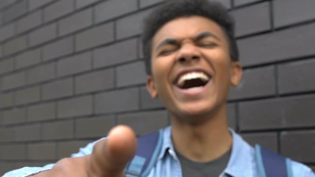African-american male student mocking victim, laughing and humiliating, POV
