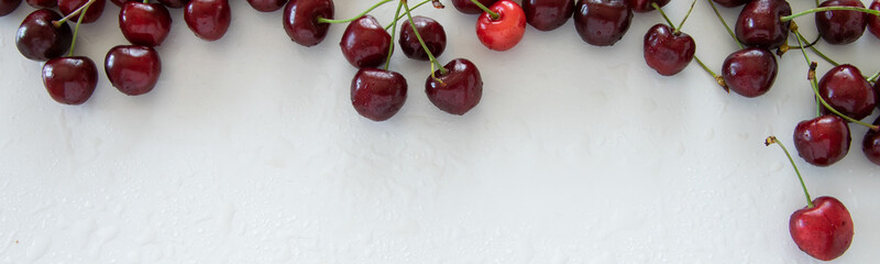 Top view of raw cherries on white background, space for text