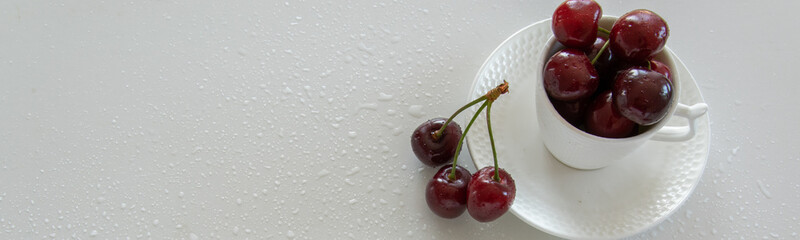 Cherries season. Top view of raw cherries in white cups and bowls