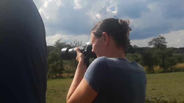Candid medium shot of young, taking photos with a DSLR in the South African Bush-veld. Shot in Leeupoort Nature Reserve, Limpopo, South Africa.