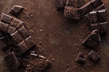 Fotobehang Bovenaanzicht van stukjes chocoladereep met chocoladeschilfers op roestmetalen achtergrond © LIGHTFIELD STUDIOS