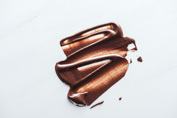 Top view of liquid dark chocolate on white background