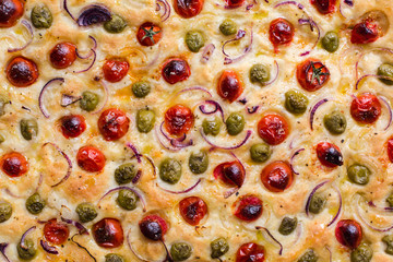 Homemade italian focaccia with tomatoes, onion and olives - flat oven baked