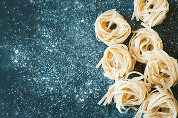 Homemade uncooked pasta on a black background