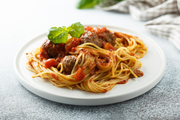 Pasta with meatballs, tomato sauce and basil