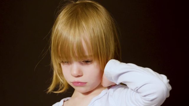 Studio portrait of a cute little blonde girl looking sad