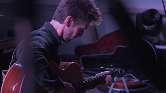 Musician tuning guitar on stage before festival