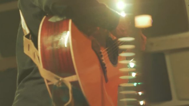 Slow motion musician playing guitar on stage at festival