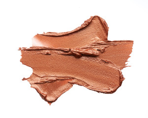 Bronze or gold texture of lip gloss or creamy eye shadow