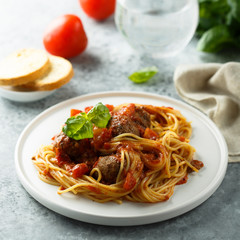 Pasta with meatballs, tomato sauce and basil