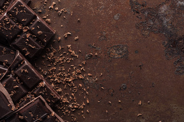 Pieces of chocolate bar with chocolate chips on metal background