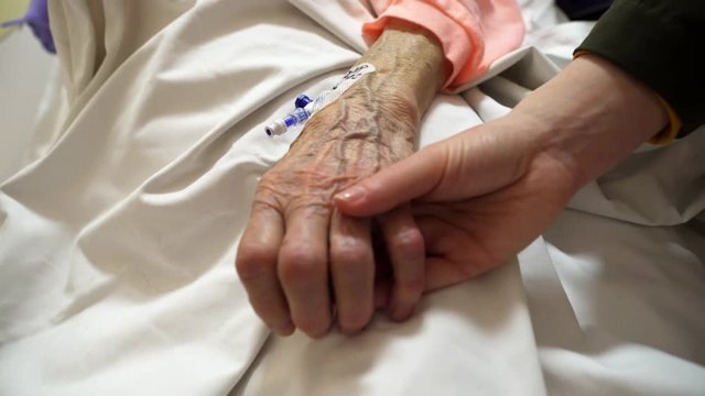 Deathbed old age care of grandmother bedridden with a  cannula, close up shot
