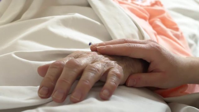 Caring for a old grandmother bedridden with a cannula, close up shot