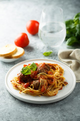 Pasta with meatballs, tomato sauce and basil