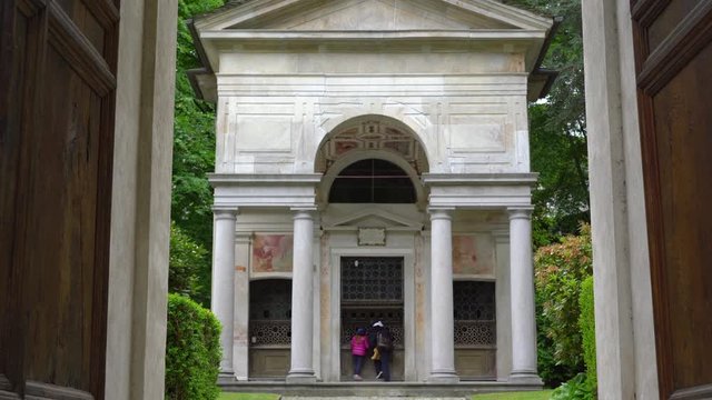 A mother and her little daughter carrying a teddy bear visiting the sacred mountain of Varallo christian devotional complex, a unesco world heritage site near the town of Varallo Sesia in Italy
