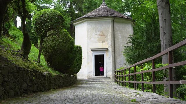 A mother and her little daughter carrying a teddy bear visiting the sacred mountain of Varallo christian devotional complex, a unesco world heritage site near the town of Varallo Sesia in Italy