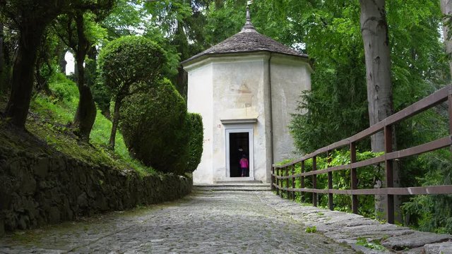 A mother and her little daughter carrying a teddy bear visiting the sacred mountain of Varallo christian devotional complex, a unesco world heritage site near the town of Varallo Sesia in Italy