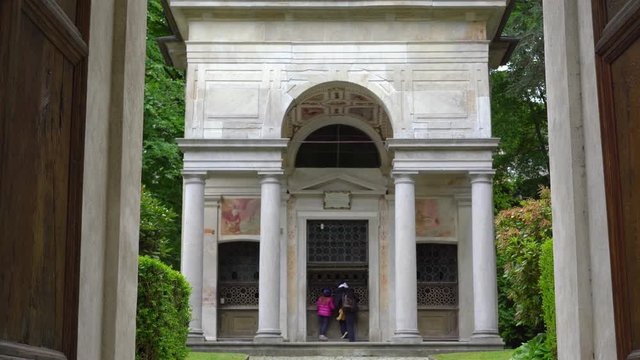 A mother and her little daughter carrying a teddy bear visiting the sacred mountain of Varallo christian devotional complex, a unesco world heritage site near the town of Varallo Sesia in Italy