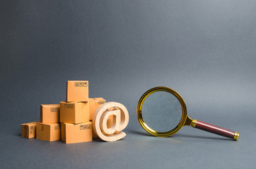 Pile of boxes with email symbol AT and a magnifying glass. Concept search for goods and services....