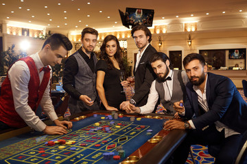 A group of friends at the casino roulette table.