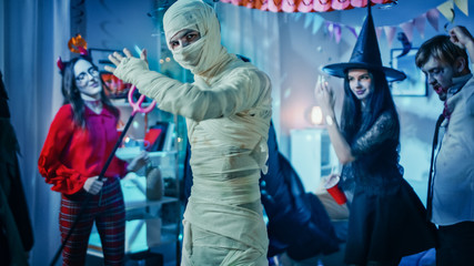 Halloween Costume Party: Old Skinny and Bandaged Mummy Dances. In the Background Zombie, Death,...
