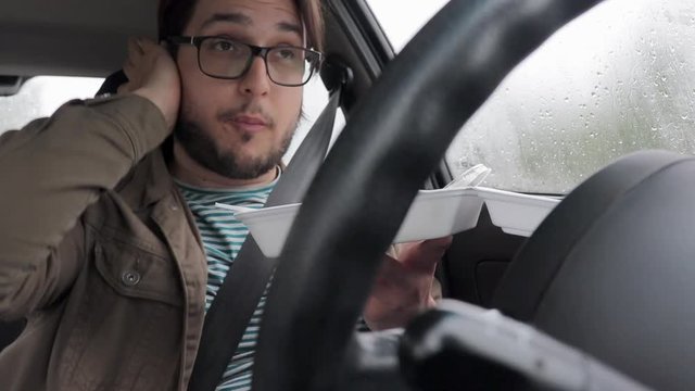 Young Driver Eats Take Away Food In His Car - Rainy Day