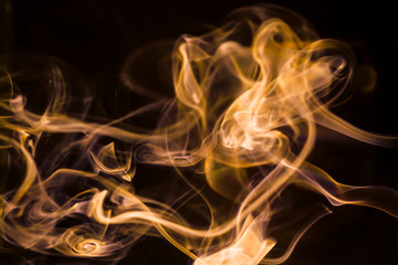 Gold smoke movement on black background.