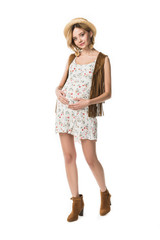 full length view of pregnant hippie girl in straw hat touching belly isolated on white