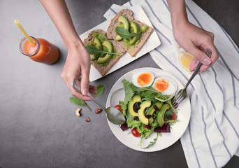 Fresh healthy vegetable salad with egg, tomato, avocado, spinach, lettuce in plate on table background.
