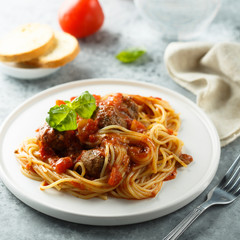 Pasta with meatballs, tomato sauce and basil