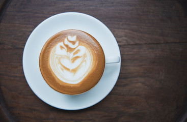latte or Cappuccino with frothy foam, coffee cup top view on table in cafe.