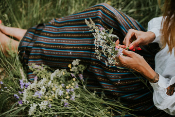 Folk girl in the midsummer making flower