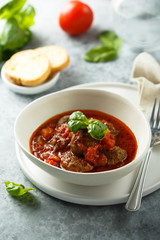 Homemade meatballs with tomato sauce and fresh basil