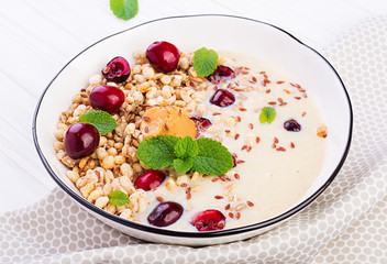 Breakfast. Bowl of homemade granola with banana mashed, peanut butter and fresh berries. Table setting. Healthy food.
