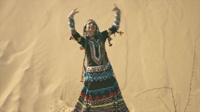 Gypsy woman dancing and clapping hands in the desert